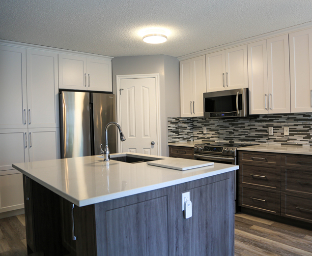 The same kitchen with pale upper fronts, dark lower fronts and updated surfaces