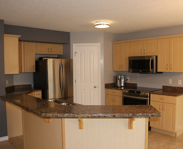 Kitchen before refacing, with light wood cabinet fronts